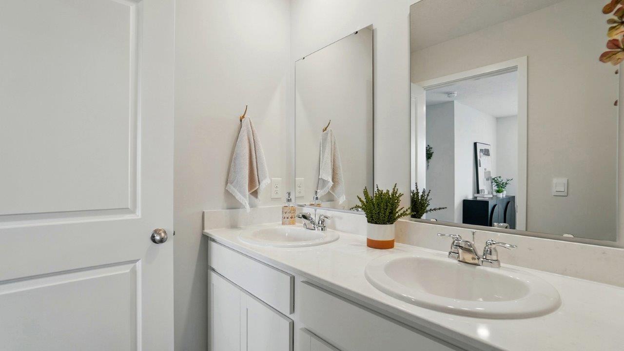 bathroom featuring dual vanity sinks with mirror above each sink
