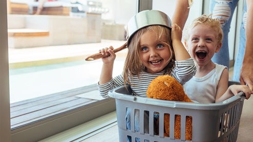 two children in laundry basket lifestyle photo