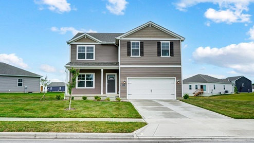 two story home with tan siding, covered front porch and tow car garage