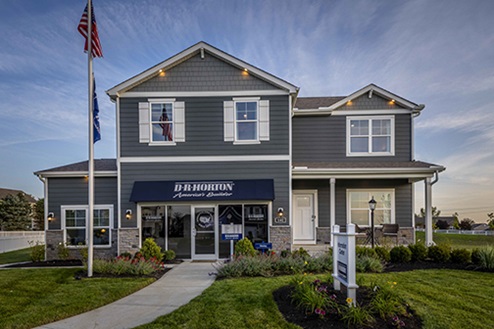 two story model home with blue siding, covered front porch, three car garage storefront