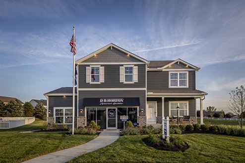 two story model home with blue siding, covered front porch, three car garage storefront