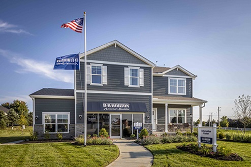 two story model home with blue siding, covered front porch, three car garage storefront