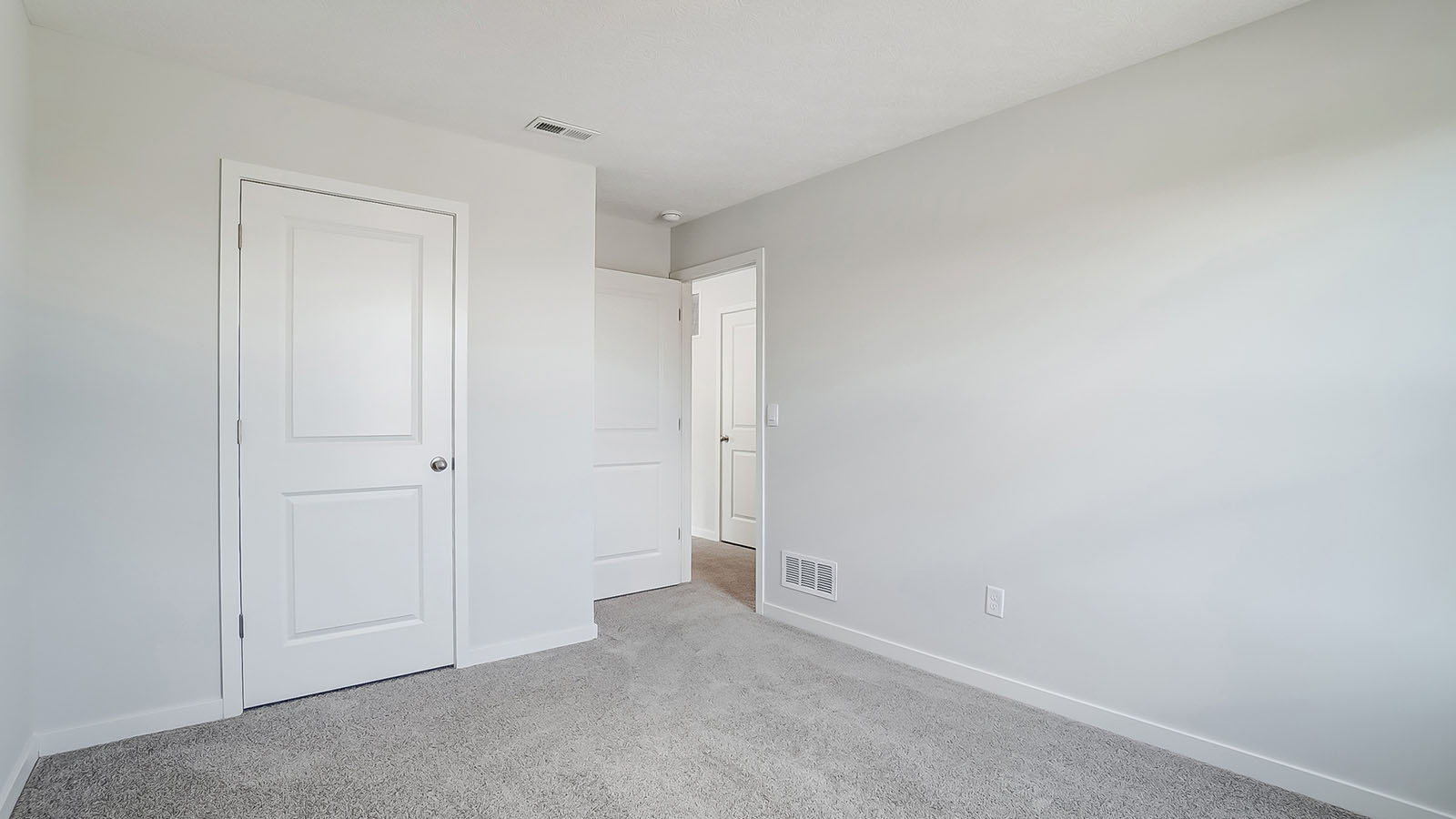 Bedroom with neutral walls, closet space, and natural lighting.