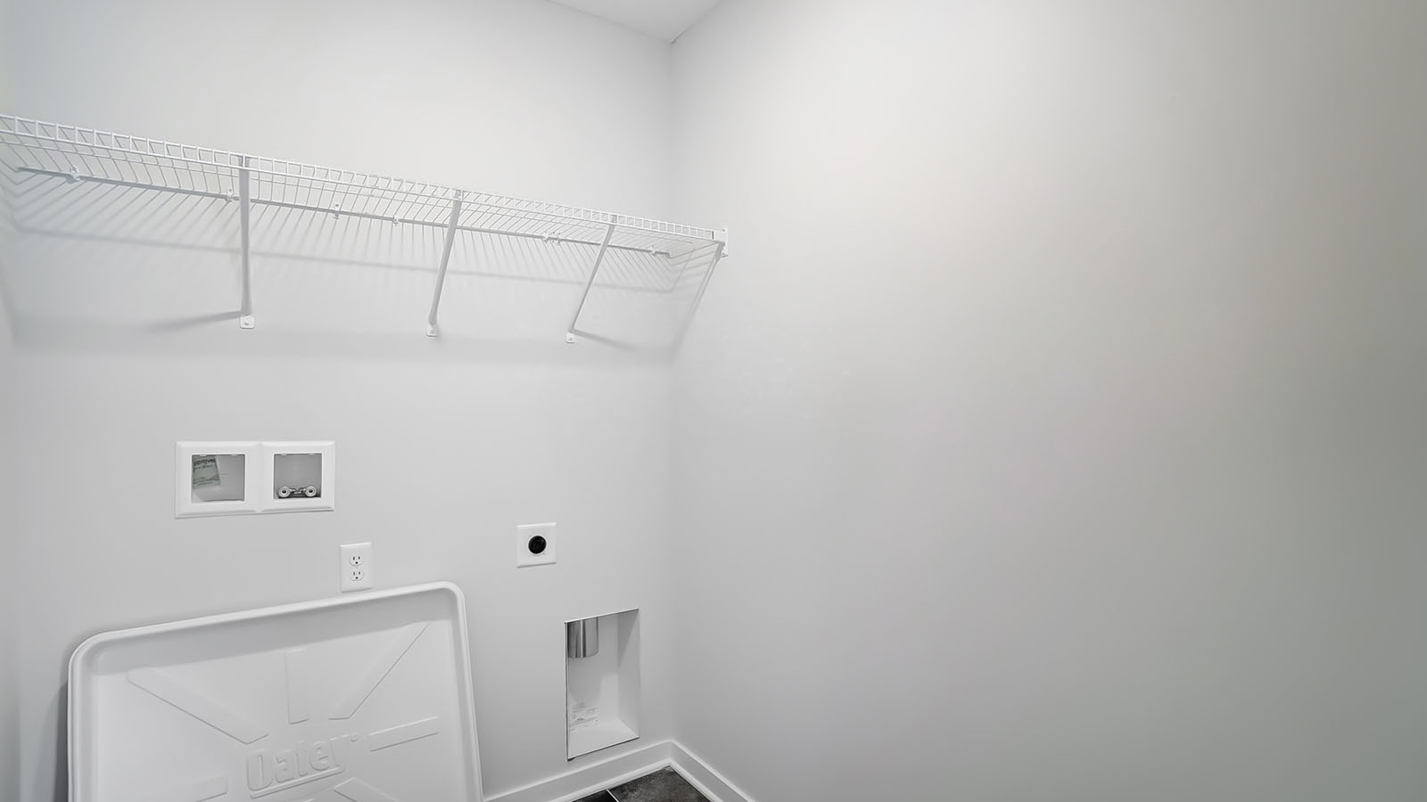 Laundry room with shelving above appliance hook ups.