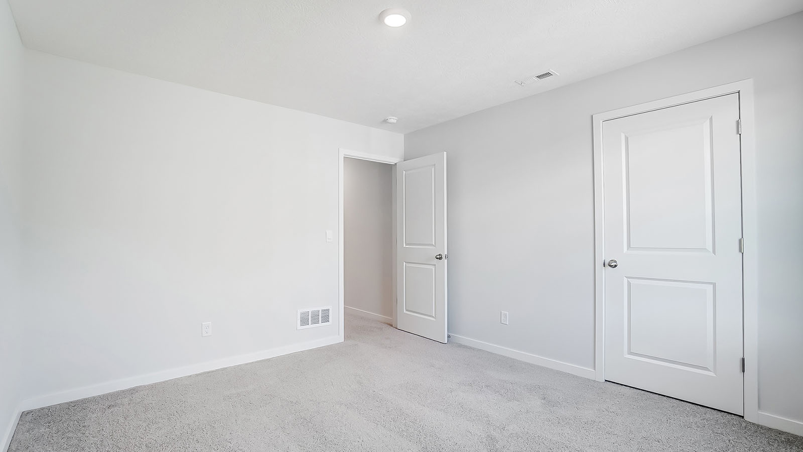 Bedroom with neutral walls, closet space, and natural lighting.