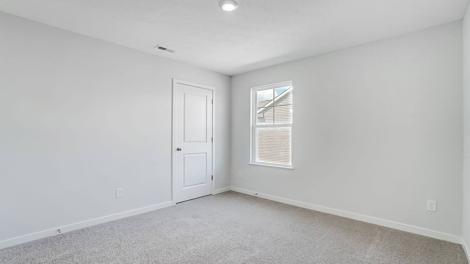 Bedroom with neutral walls, closet space, and natural lighting.