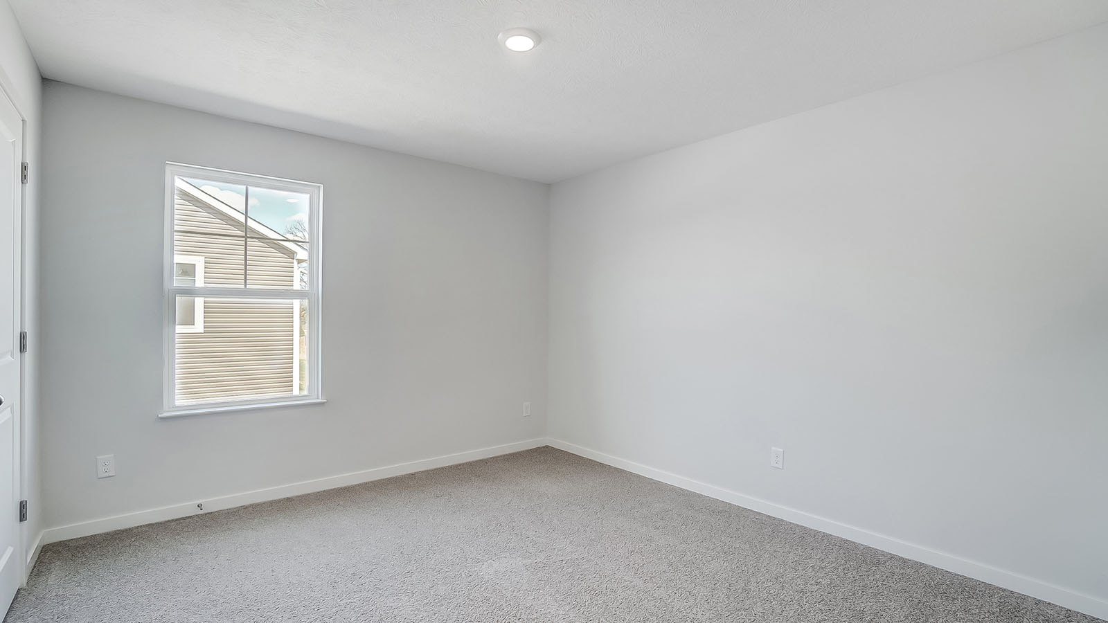 Bedroom with neutral walls, closet space, and natural lighting.