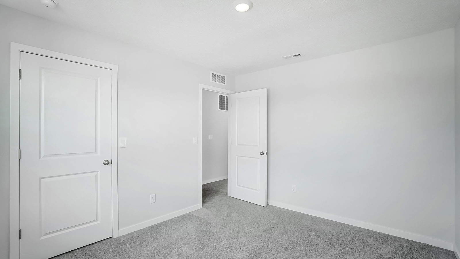 Bedroom with neutral walls, closet space, and natural lighting.