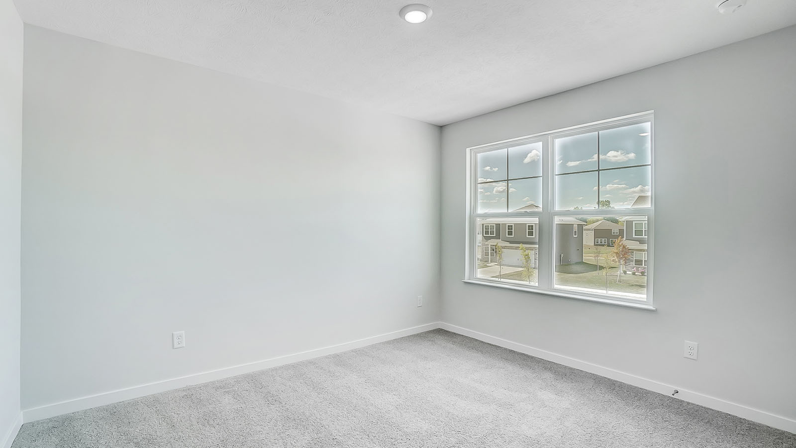 Bedroom with neutral walls, closet space, and natural lighting.