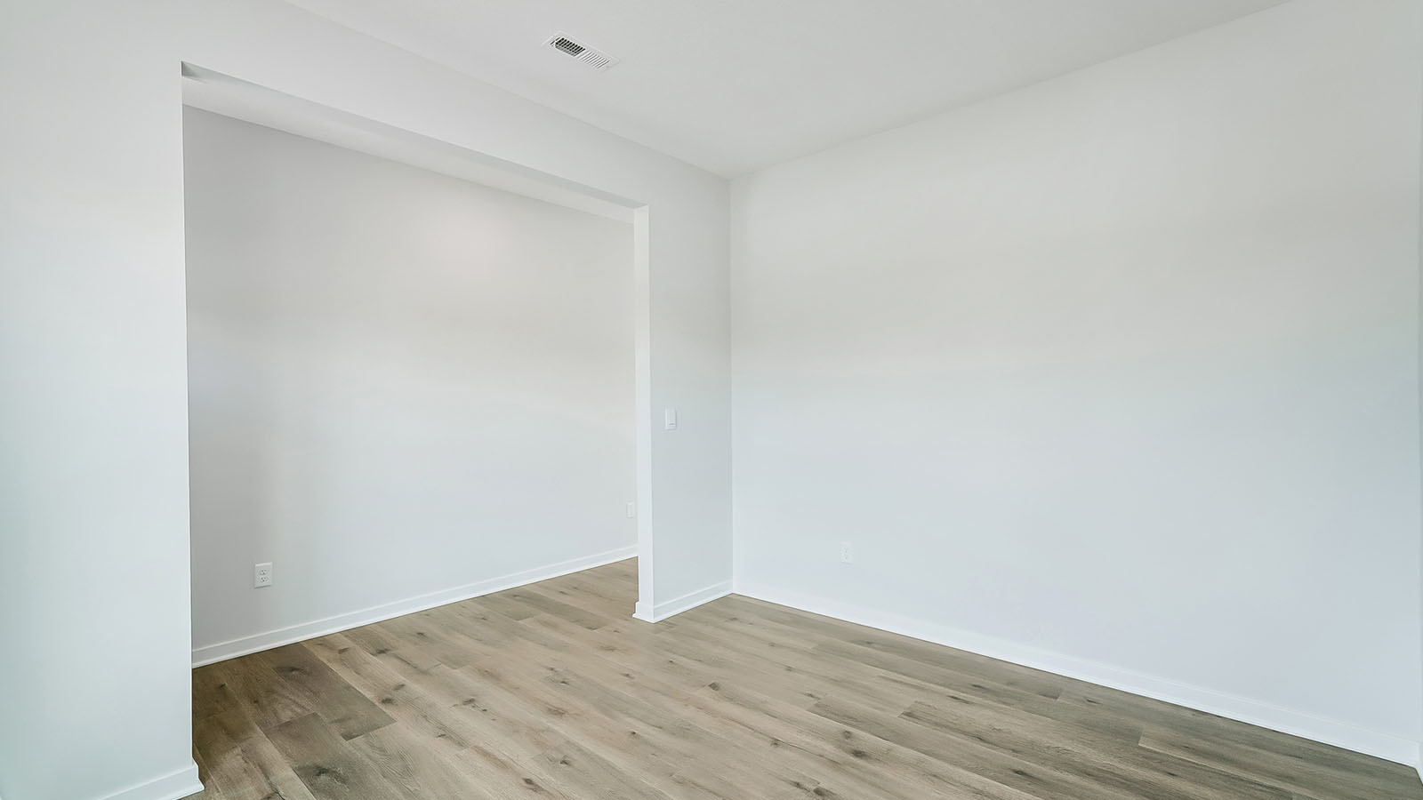 Dining area with large window and white walls.