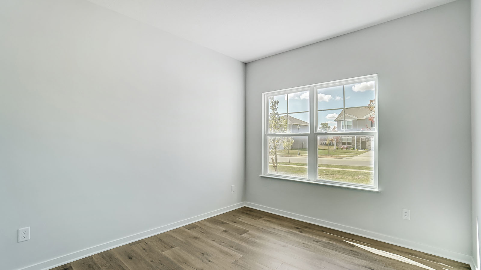 Dining area with large window and white walls.