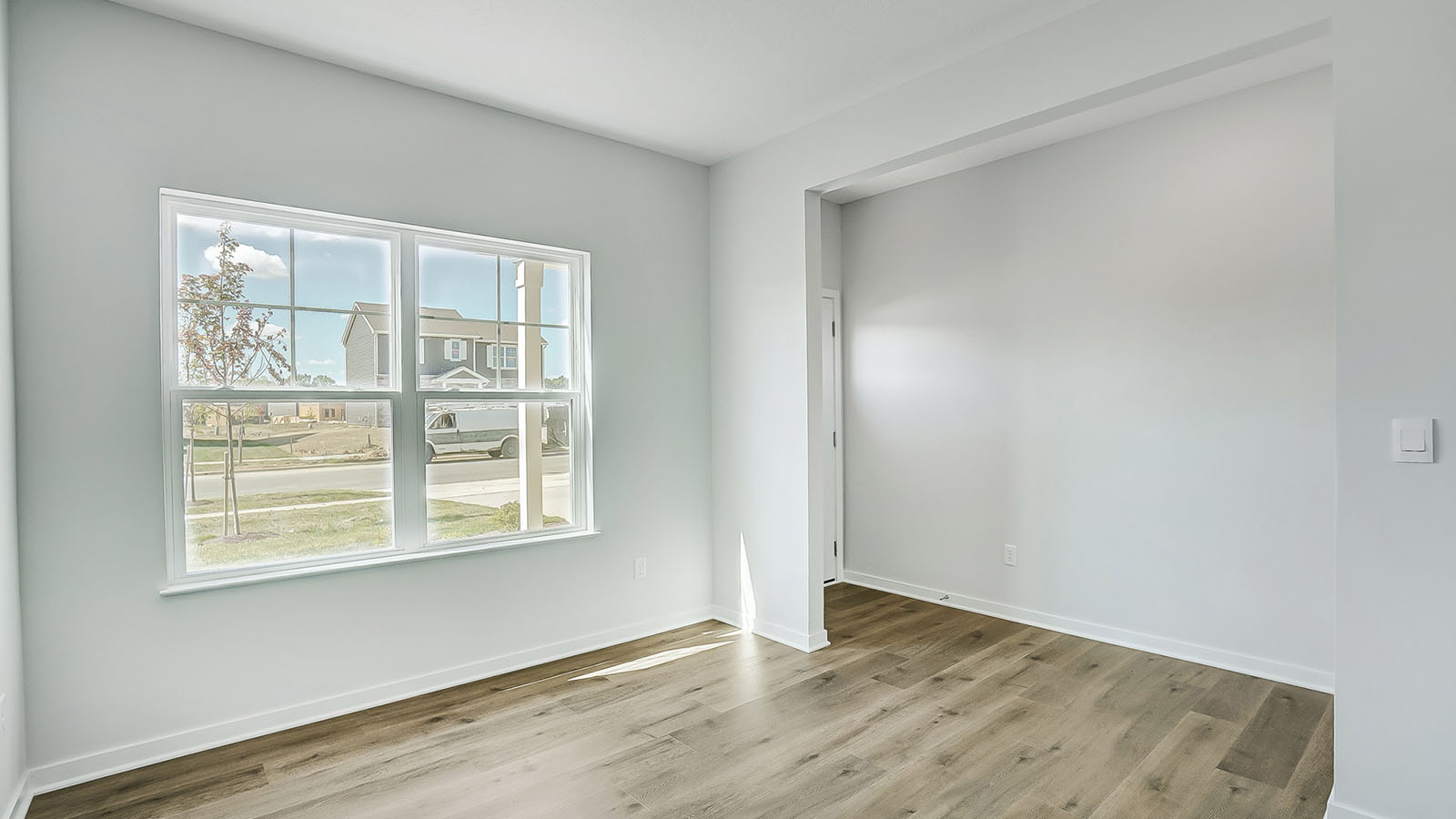 Dining area with large window and white walls.