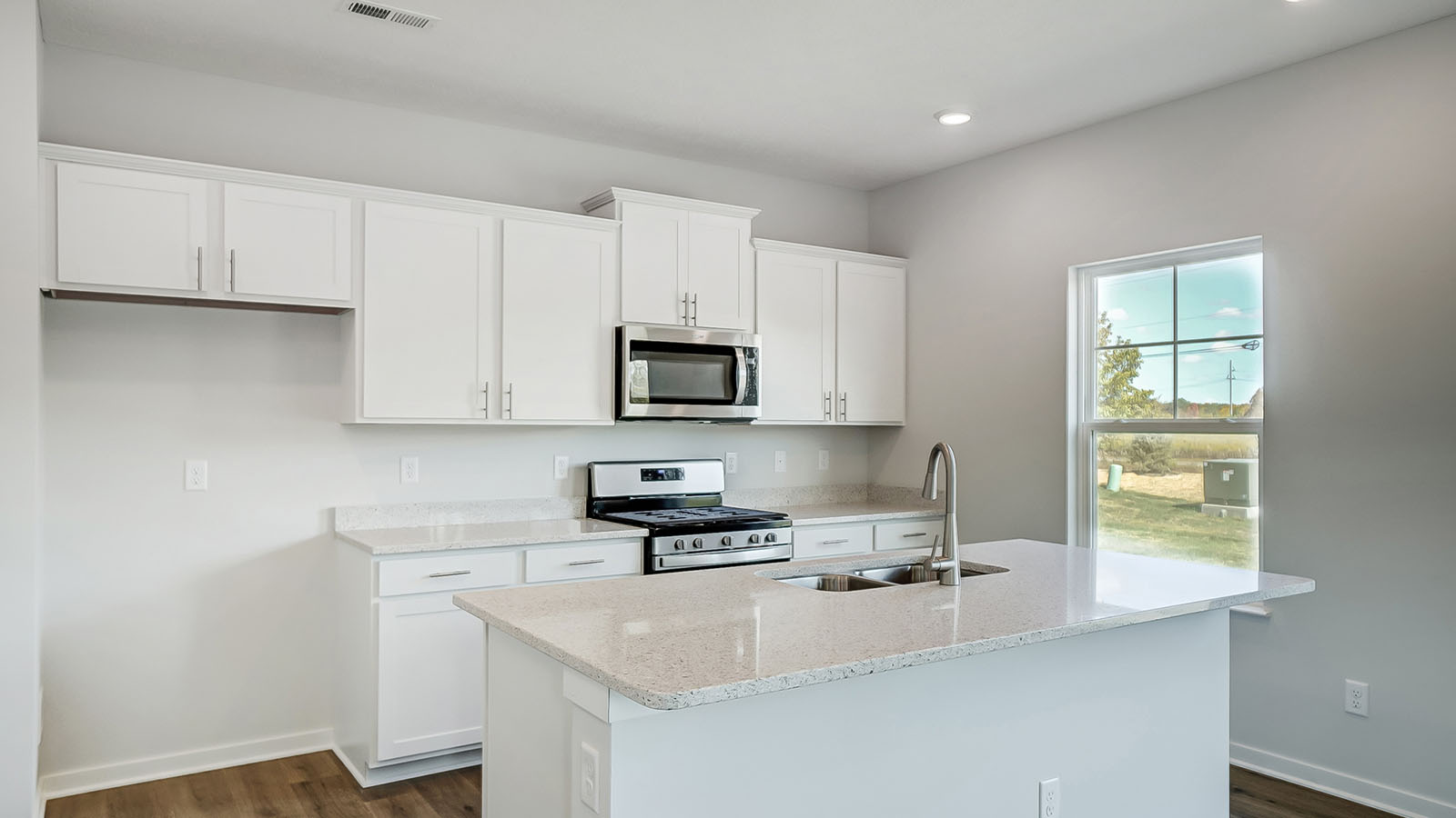 Kitchen featuring white cabinets, new stainless steel appliances, and white countertops.