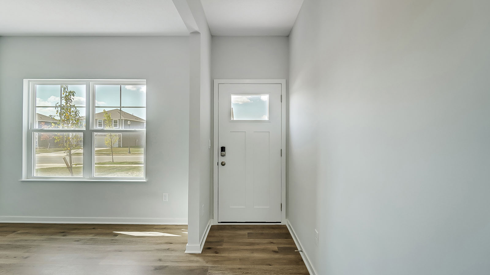 front entry way of home featuring brown flooring and white walls
