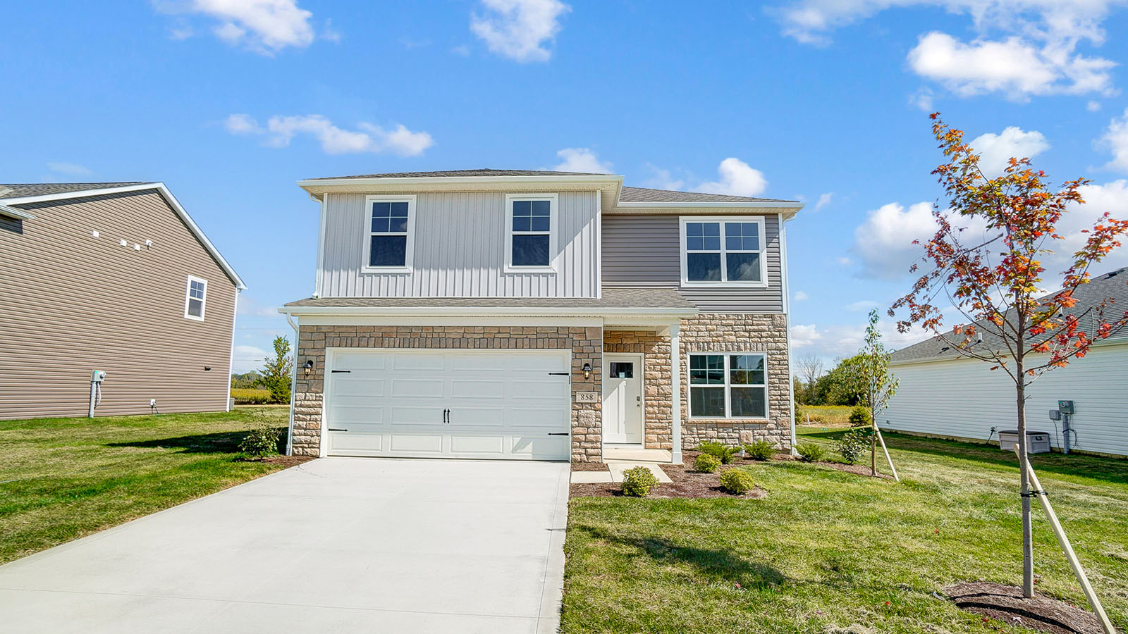 front exterior of a two story home with stucco exterior and a two car garage