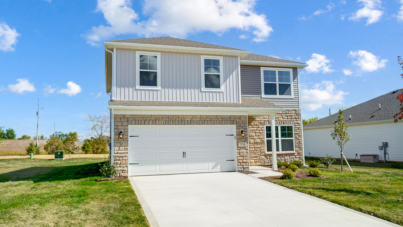 front exterior of a two story home with stucco exterior and a two car garage