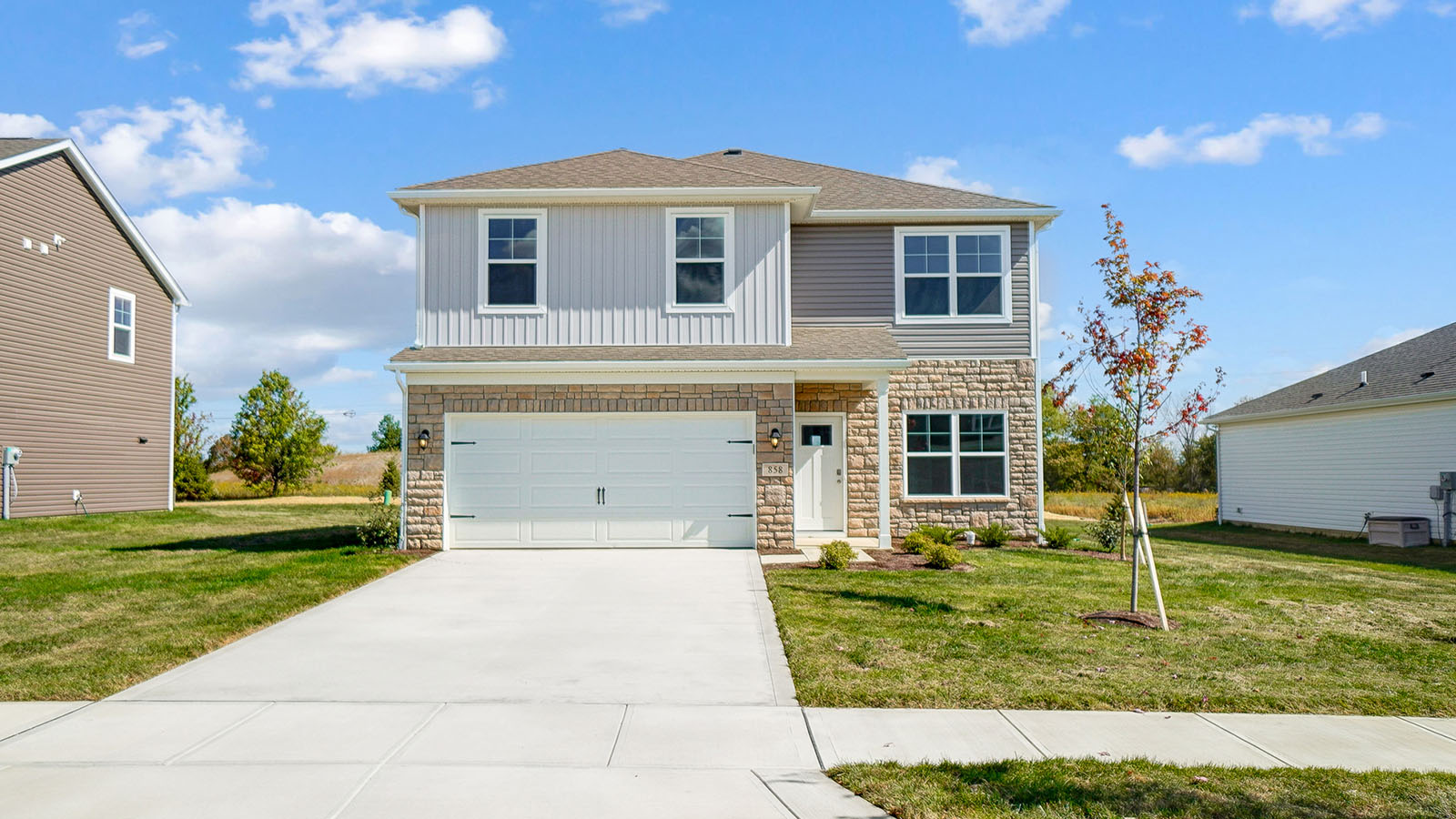 front exterior of a two story home with stucco exterior and a two car garage