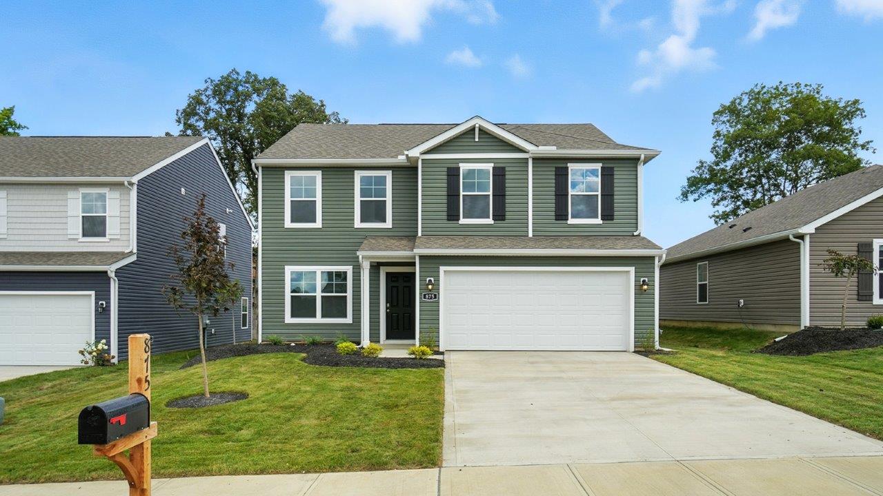 two story home with green siding, covered entry and two car garage