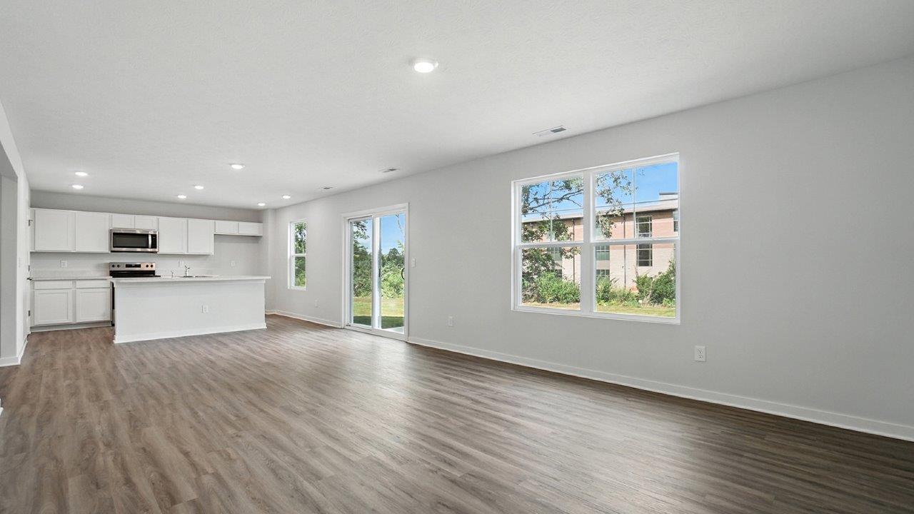 great room with double window, rear sliding door and kitchen