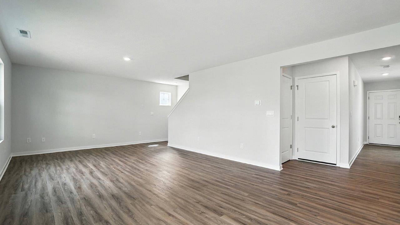 great room with tucked staircase and foyer