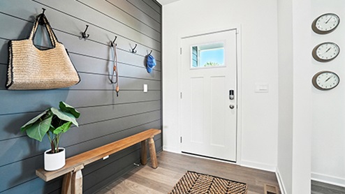 Entry way with wood detailing, bench and hooks.