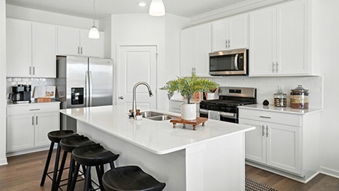 Kitchen Island View with Black barstools, white cabinets and stainless steel appliances