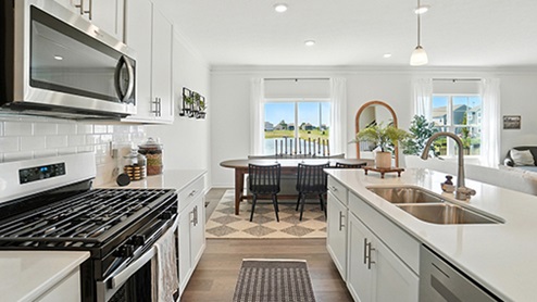 Kitchen Island View with Black barstools, white cabinets and stainless steel appliances