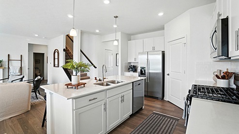 Kitchen Island View with Black barstools, white cabinets and stainless steel appliances