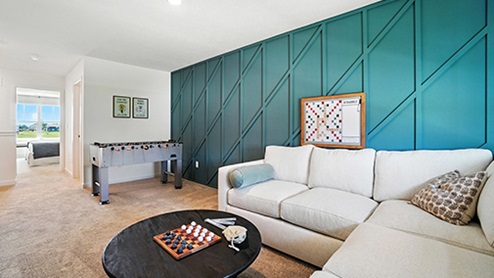 Loft space with cream sofa, dark coffee table, foosball table with teal wall with wood detail
