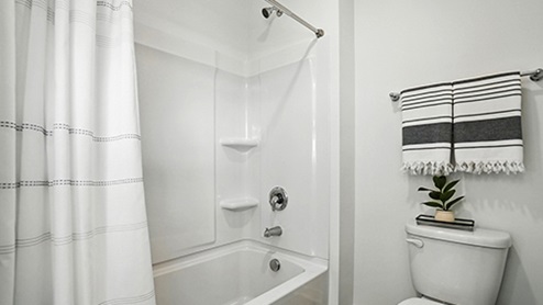 Bathroom with light gray cabinets featuring dual sinks and mirrors