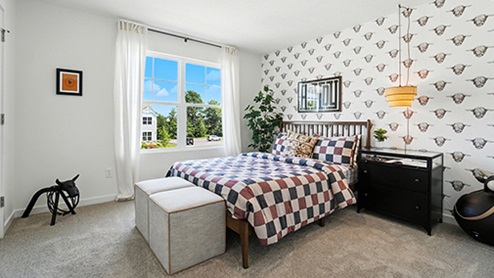 Boy’s bedroom decorated with checkered bedding and western themed wallpaper