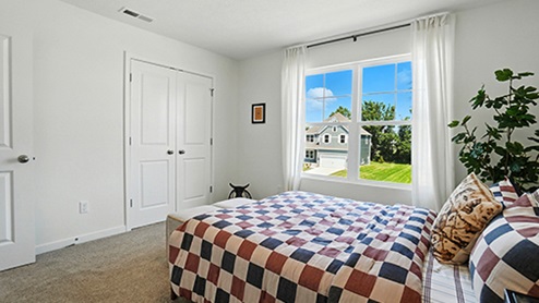 Boy’s bedroom decorated with checkered bedding and western themed wallpaper