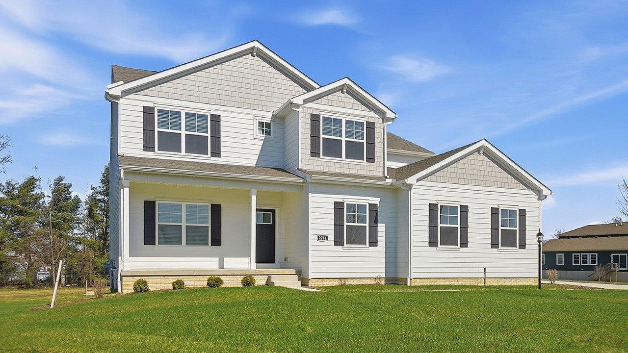 Two story home with white siding, black shutters, covered front porch and sideload garage