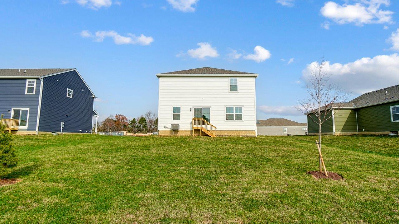rear exterior of home featuring a spacious backyard