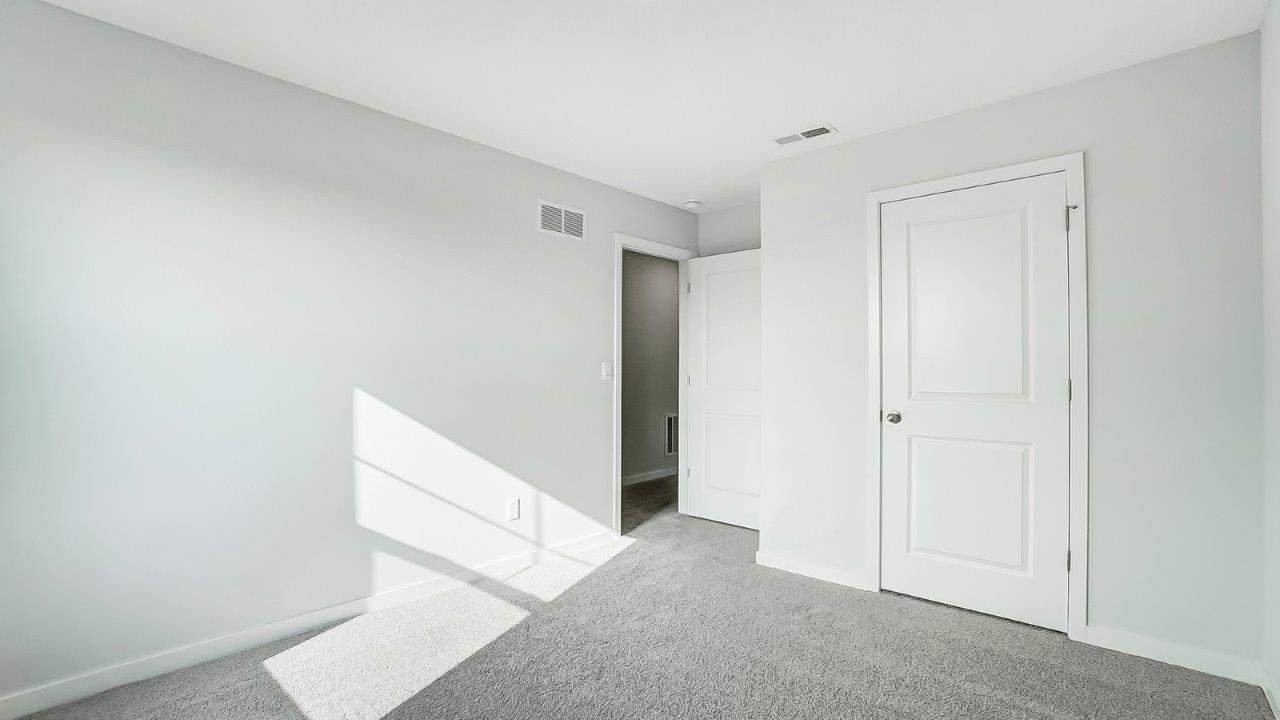 bedroom with grey carpet, grey walls and a window
