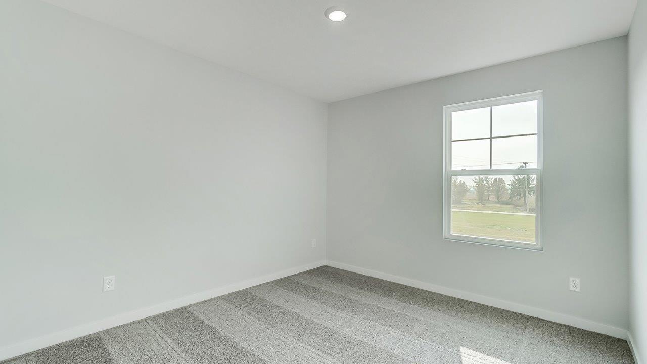 bedroom with grey carpet, grey walls and a window