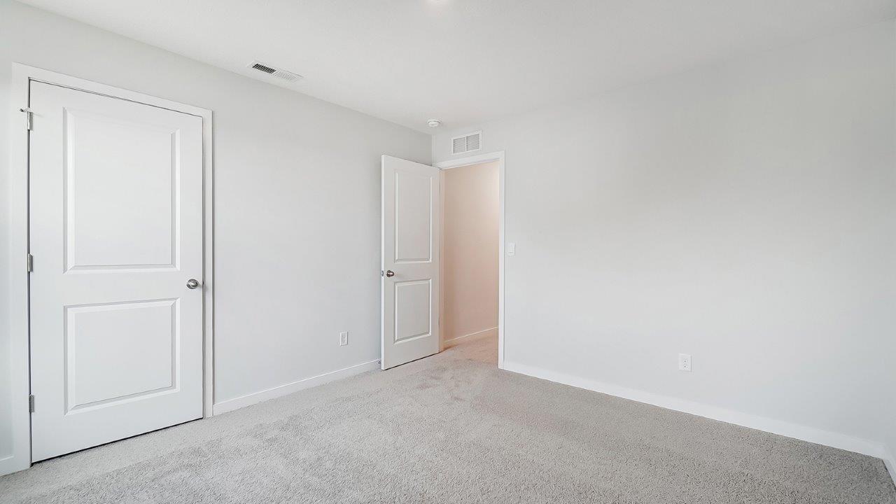 bedroom with grey carpet, grey walls and a window