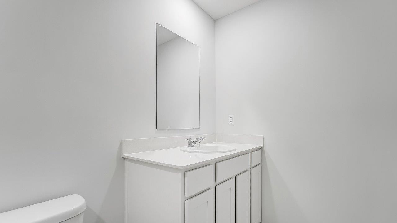 bathroom with a vanity sink, toilet, and a walk in shower