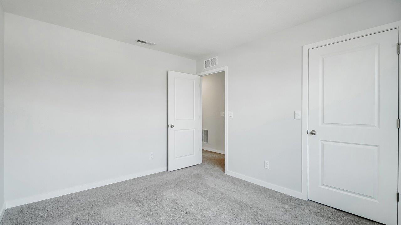 bedroom with grey carpet, grey walls and a window