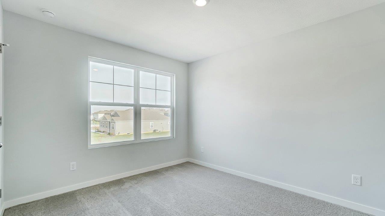 bedroom with grey carpet, grey walls and a window