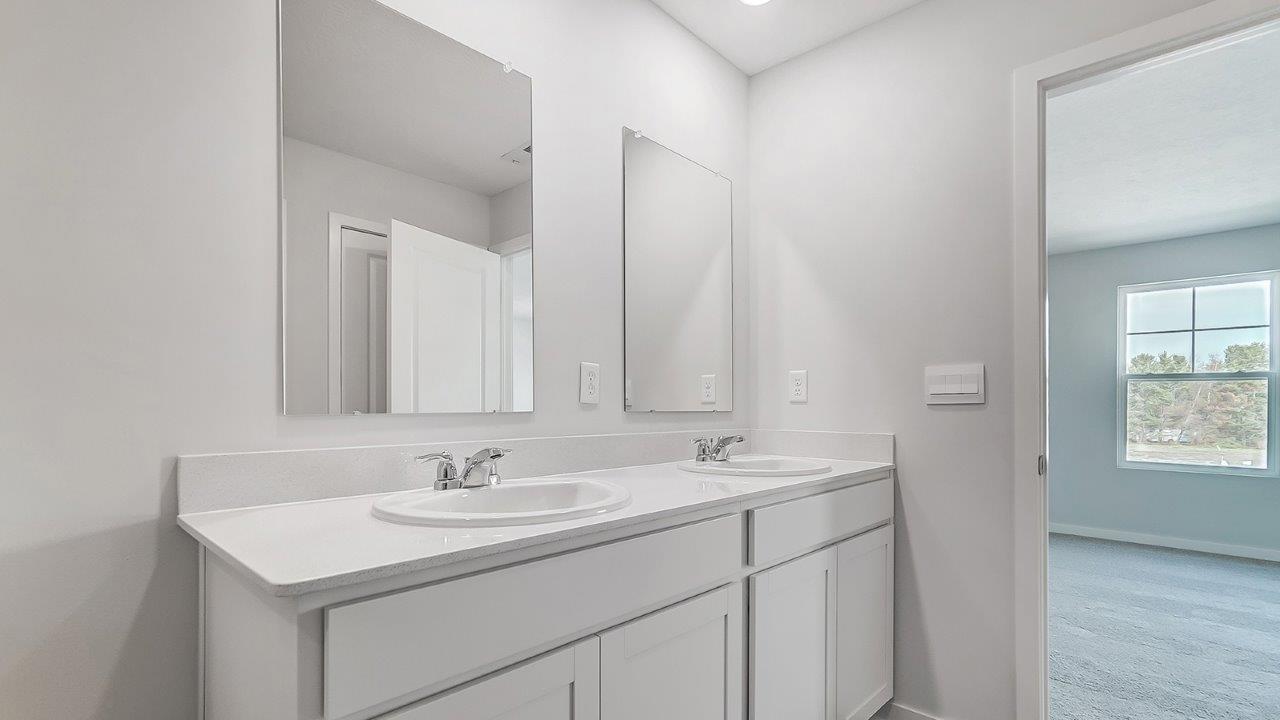 bathroom with dual vanity sinks, toilet and a shower