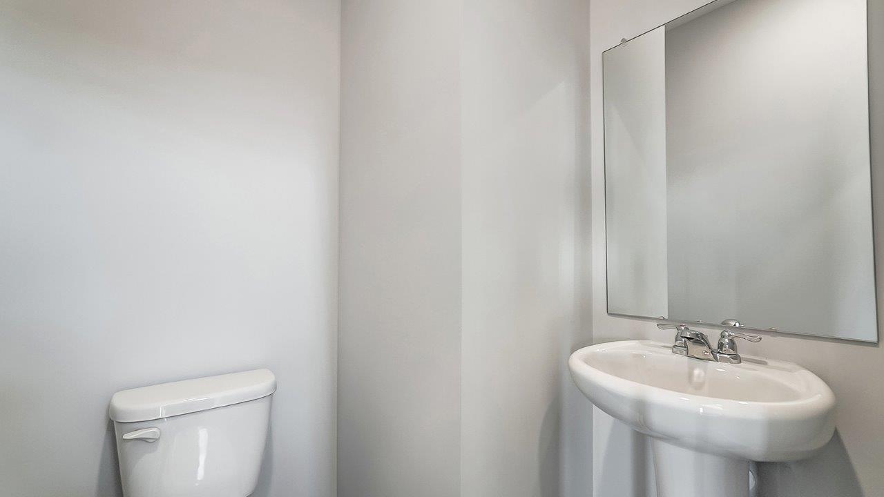 Powder bathroom with a pedestal sink and mirror