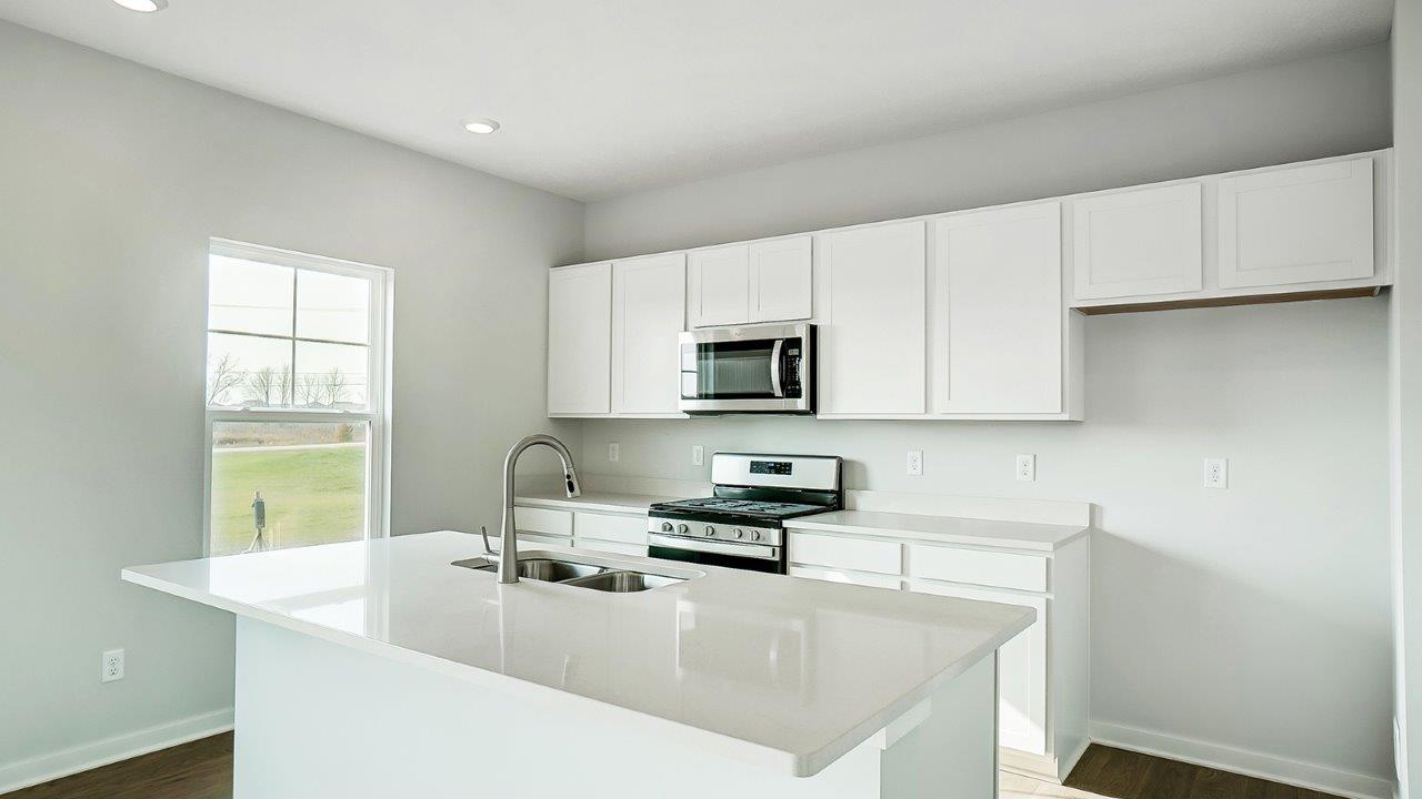 kitchen with white cabinetry, large island, and stainless steel appliances