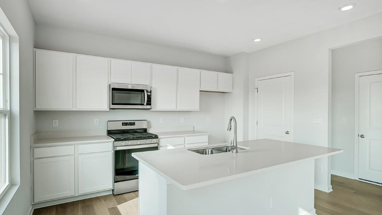 kitchen with white cabinetry, large island, and stainless steel appliances