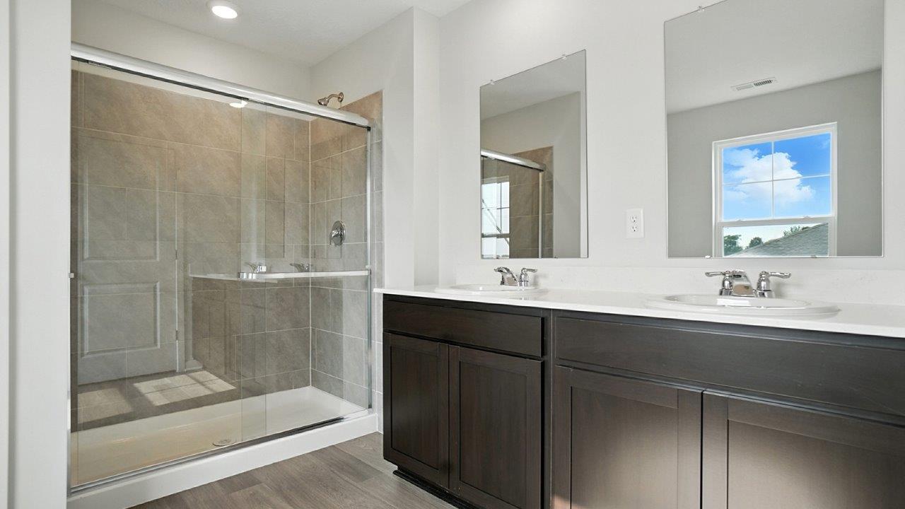 primary ensuite bath with double vanity and walk in shower