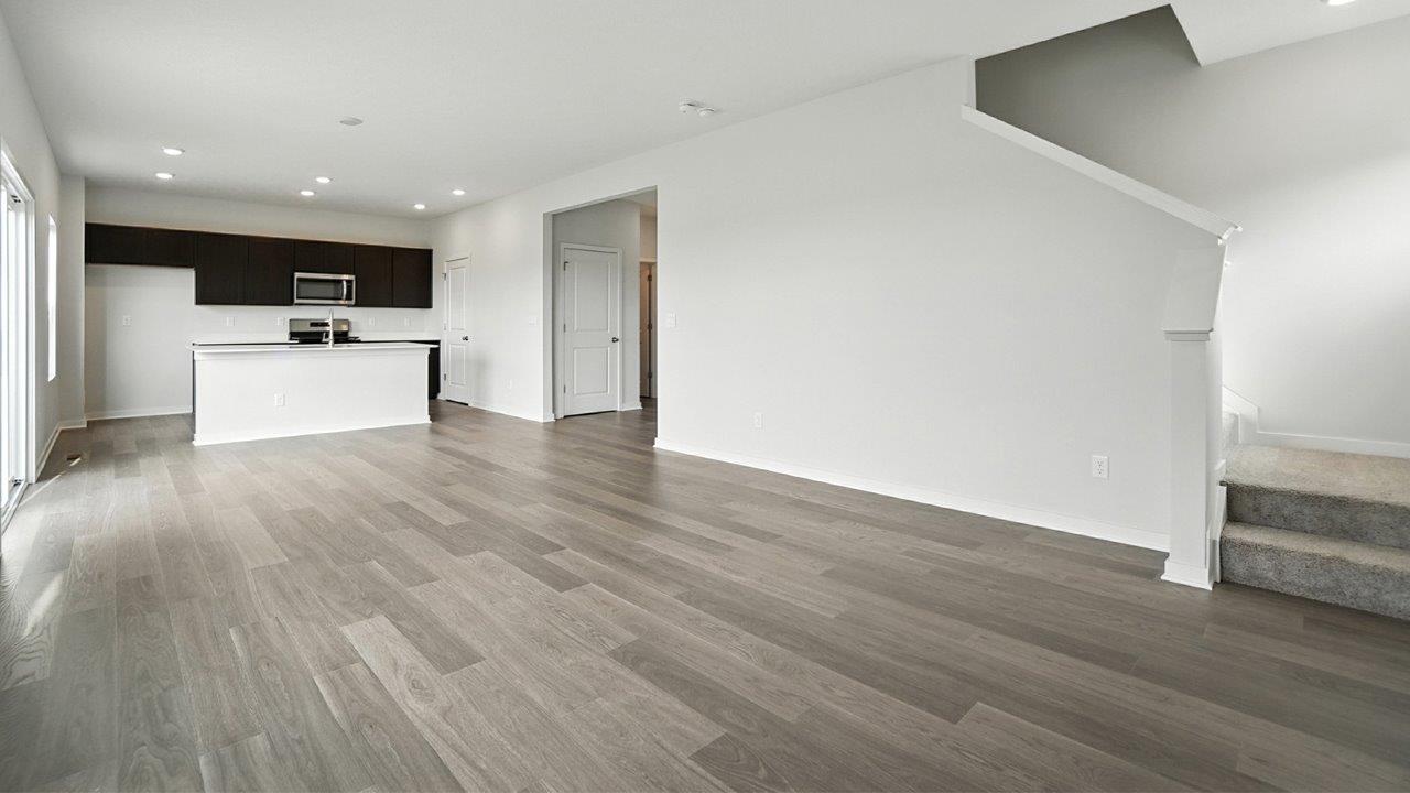 great room with turnback stairs and kitchen