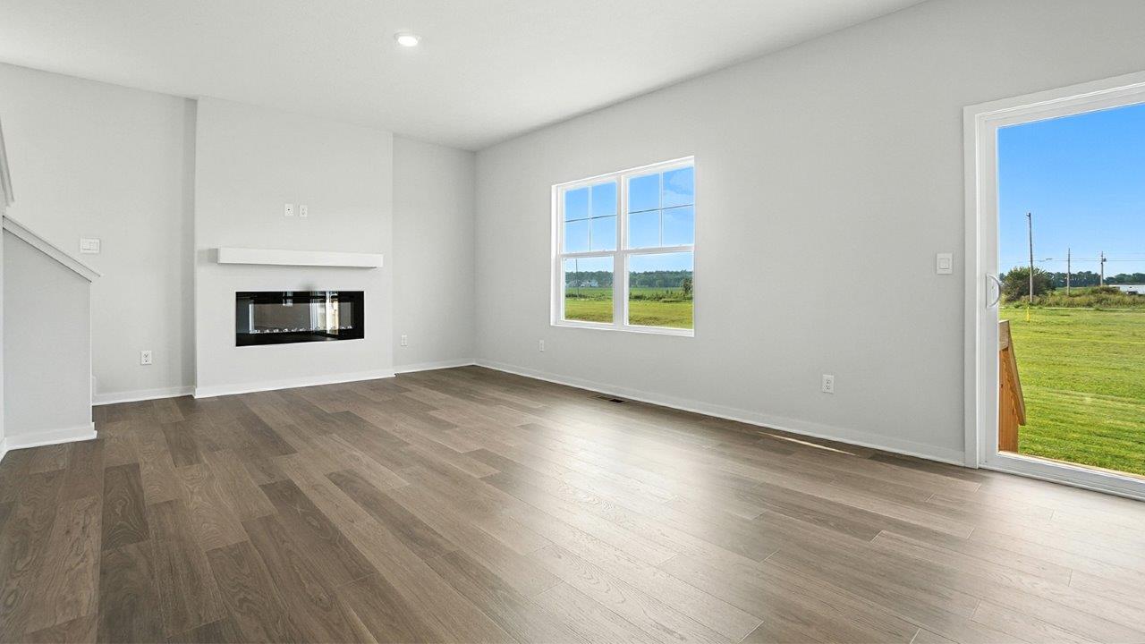 great room with double window, rear sliding door and electric fireplace