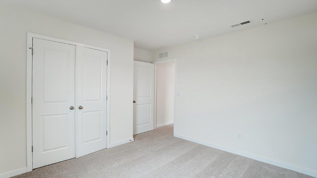 View of the bedroom overlooking the closet and hallway doors