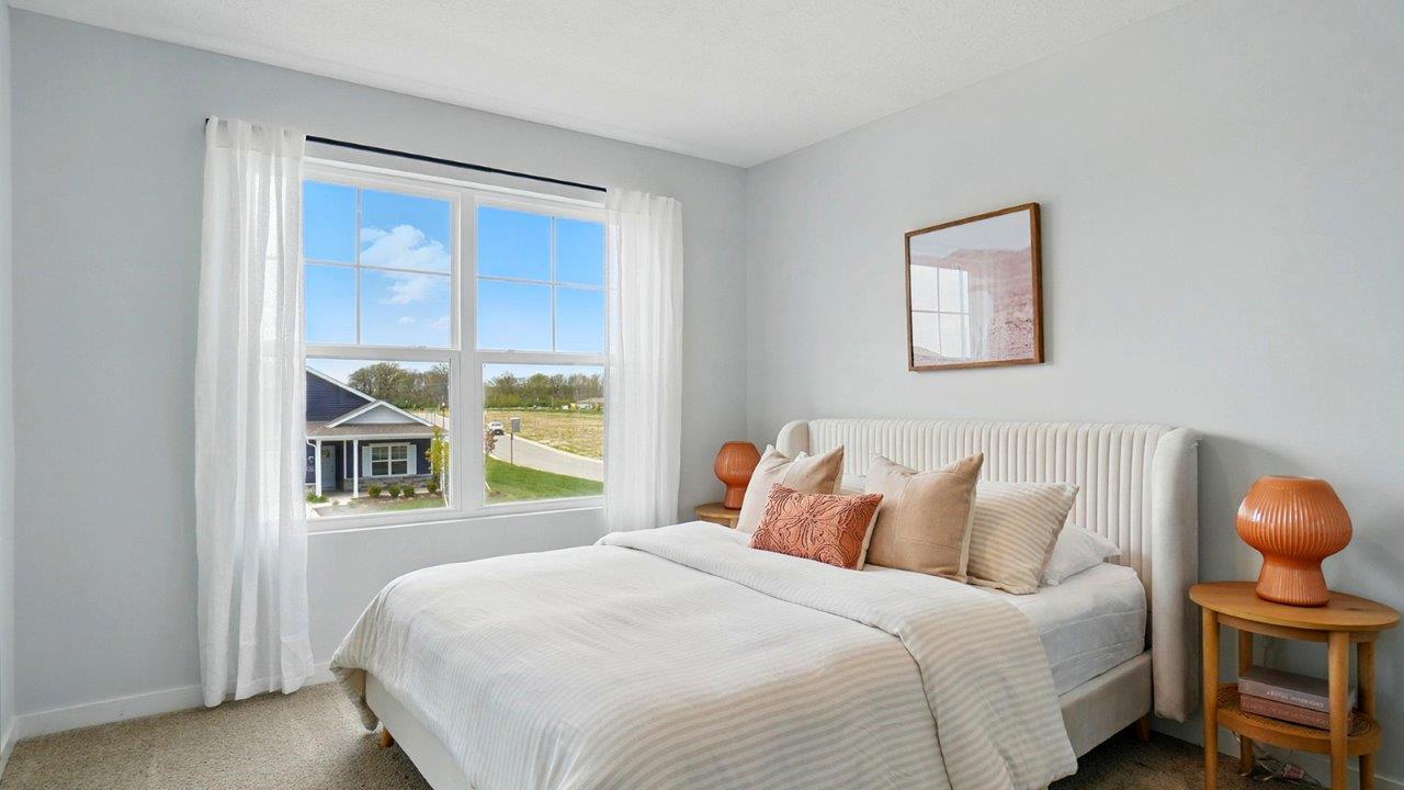 bedroom with a white bed, large window and brown night stand