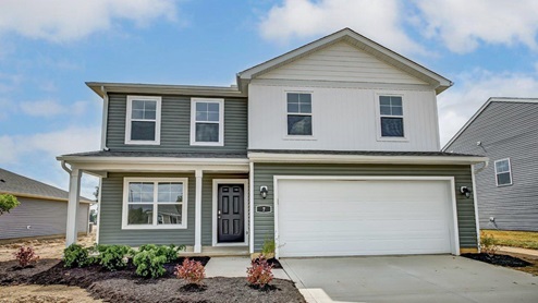 Two story home with green and white siding, covered front porch and two car garage